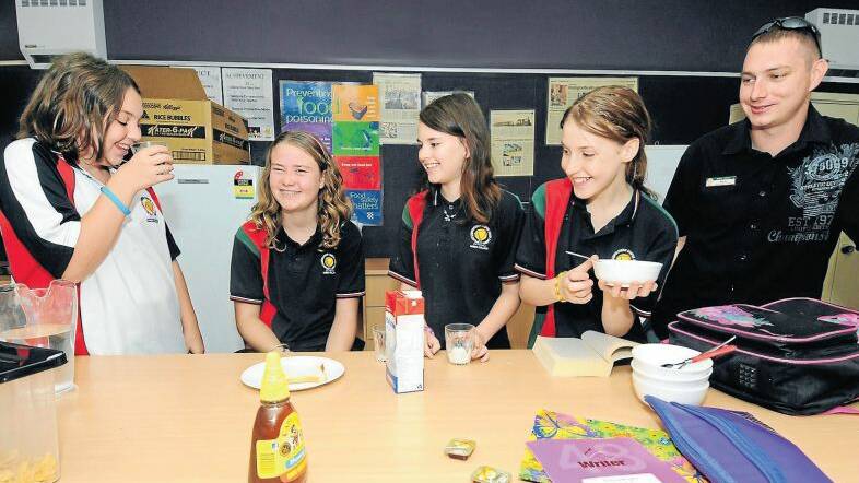 Emma-Rose Moran, Courtney Charlton, Bianca-Leigh Rogers and Ashleigh Sendt with student support officer Aaron Jackson enjoy breakfast at
Dubbo College South Campus. Photo: LOUISE DONGES