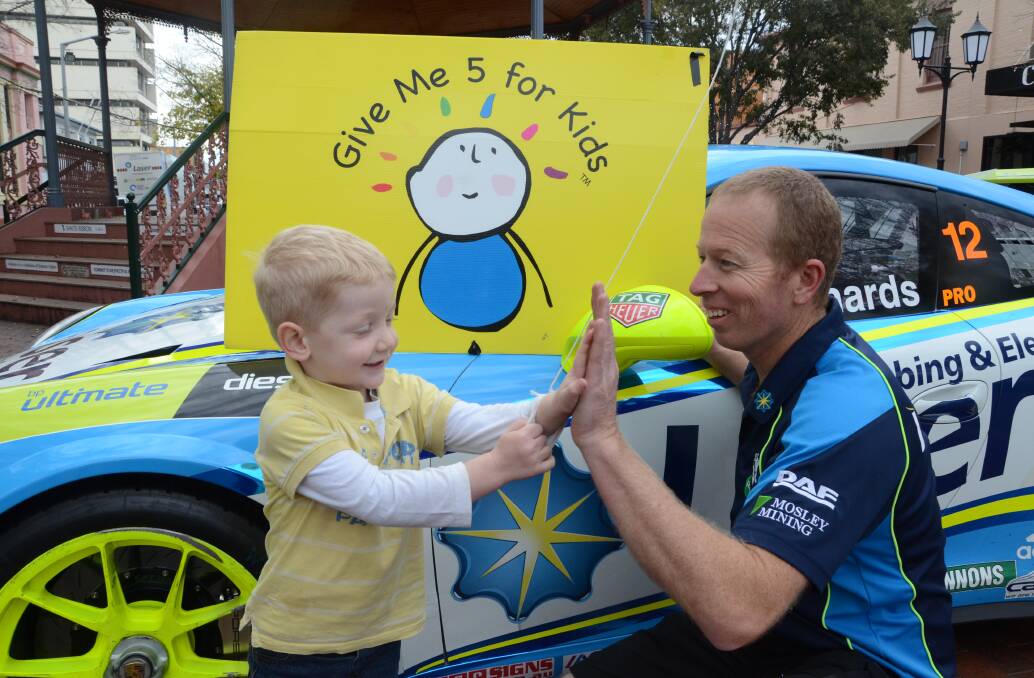 Andrew Cullenward gets a high-five from Porsche Carrera Cup race driver Steven Richards, who is in Dubbo raising money for the local children's ward. Photo: JENNIFER HOAR