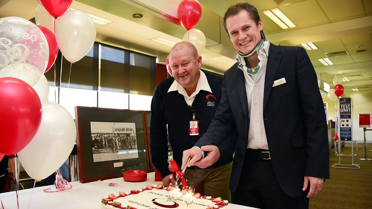 Dubbo Mayor Mathew Dickerson and airport operations manager Lindsay Mason cut a cake to celebrate the airport’s 80th birthday. Photo: BELINDA SOOLE