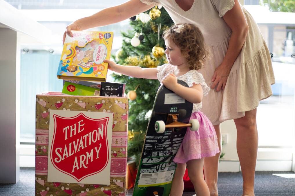 MAKING A DIFFERENCE: Toddler Elle donating to Newcastle Permanent's gift appeal to support The Salvation Army toy drive. Photo: CONTRIBUTED