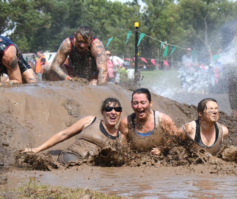 HAD SLOG: Tracey Spence, Tiffany Girlich and Nicole Walsh falling into the mud at a previous Titan Macquarie Mud Run. Photo: FILE