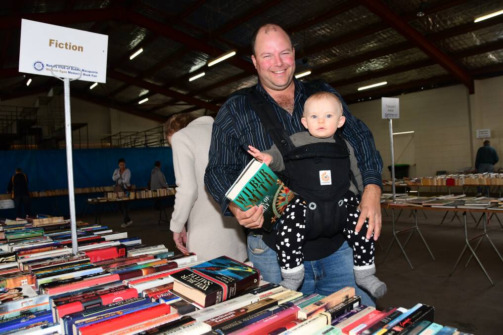 DIVING INTO A GOOD BOOK: Dave Leneham exploring the range of fiction books available at the Michael Egan Memorial Book Fair at the weekend with baby George. Photo: AMY McINTYRE