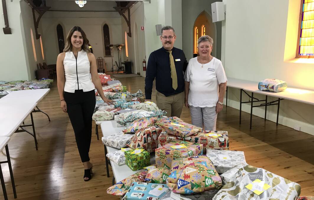TOYS: Olivia Rabbett and Anthony Walkom from Ray White Dubbo with St Vincent de Paul's Carole O'Connor ready to bring some Christmas joy. Photo: CONTRIBUTED
