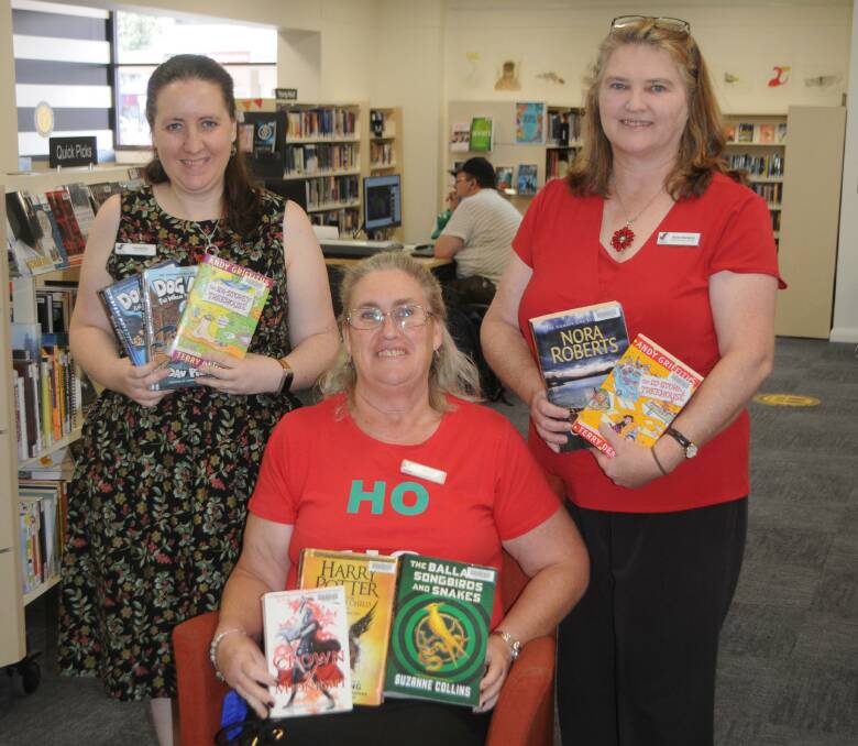 TOP SHELF: Macquarie Regional Library staff Samantha Starr, Michelle Betts and acting manager Anne Barwick with some of the most popular picks for the year. Photo: ORLANDER RUMING