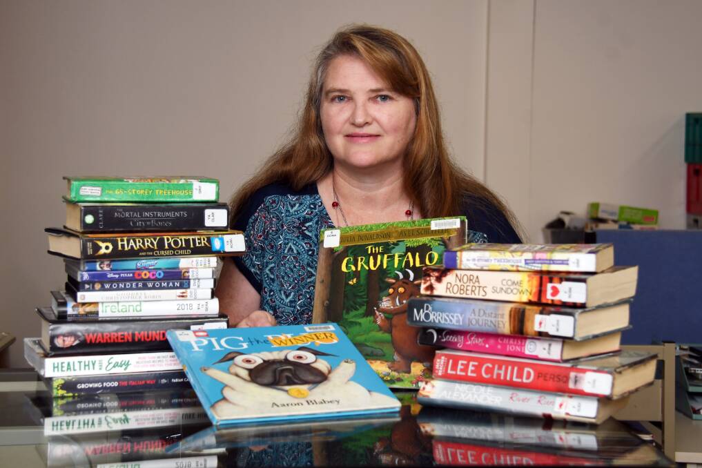 PUGS AND MAGIC: Acting Dubbo libraries coordinator Anne Barwick with some of the most borrowed titles for the year. Photo: BELINDA SOOLE