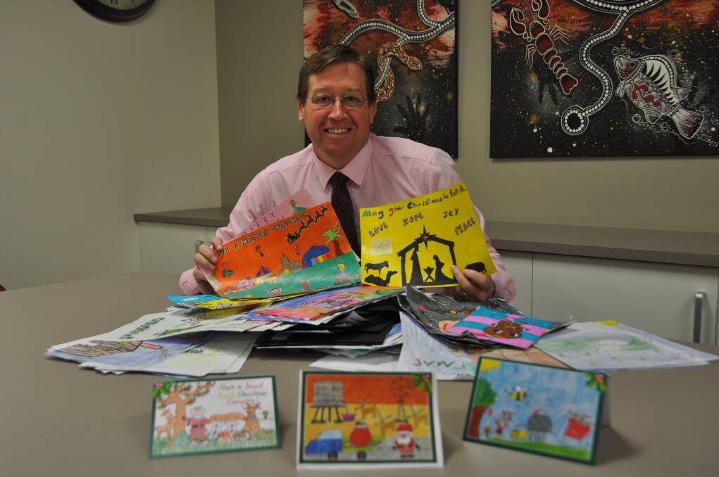 Dubbo MP Troy Grant with some of the designs entered into last year's Christmas card competition. Photo: CONTRIBUTED