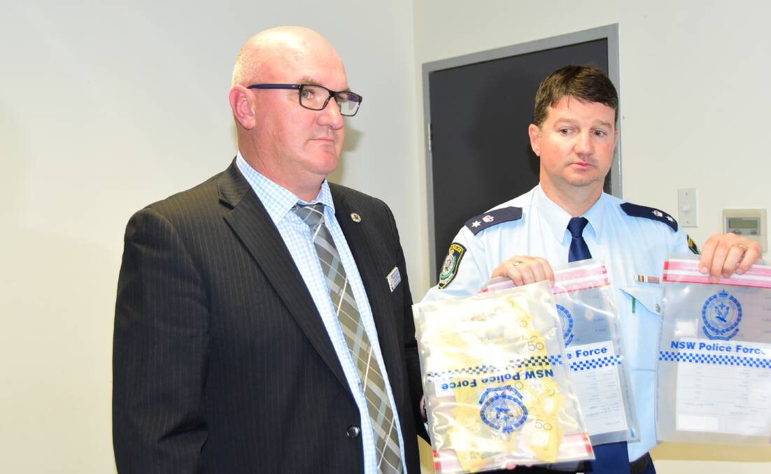 Off the streets: Detective Sergeant Adrian Tighe and Acting Superintendent Scott Tanner with some of the cash and drugs seized earlier in the year. Photo: BEN WALKER