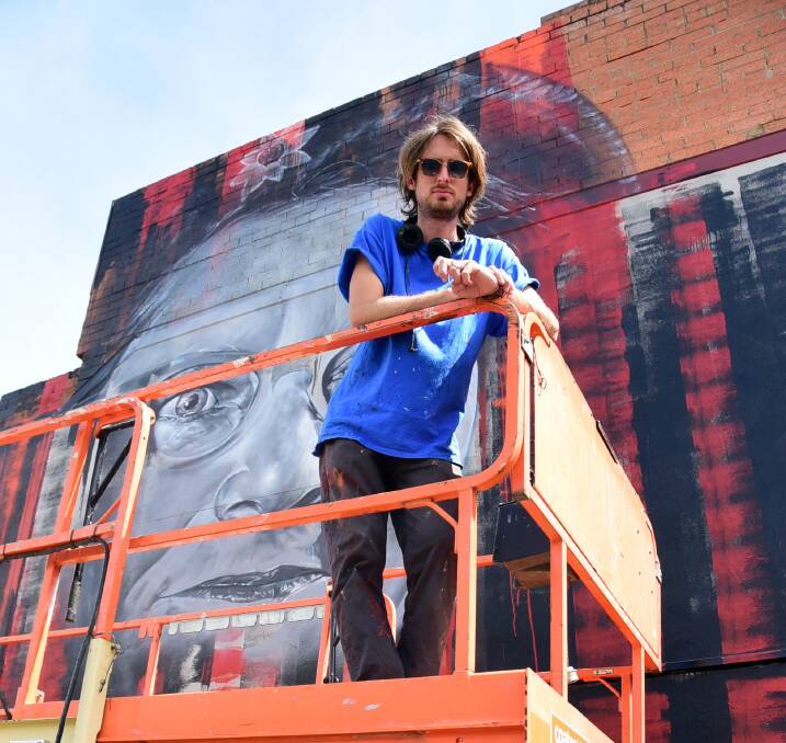 Matt Adnate when he was working on a portrait of Pearl Gibbs on the corner of Talbragar and Darling streets. The artwork is one of many included in the tour.