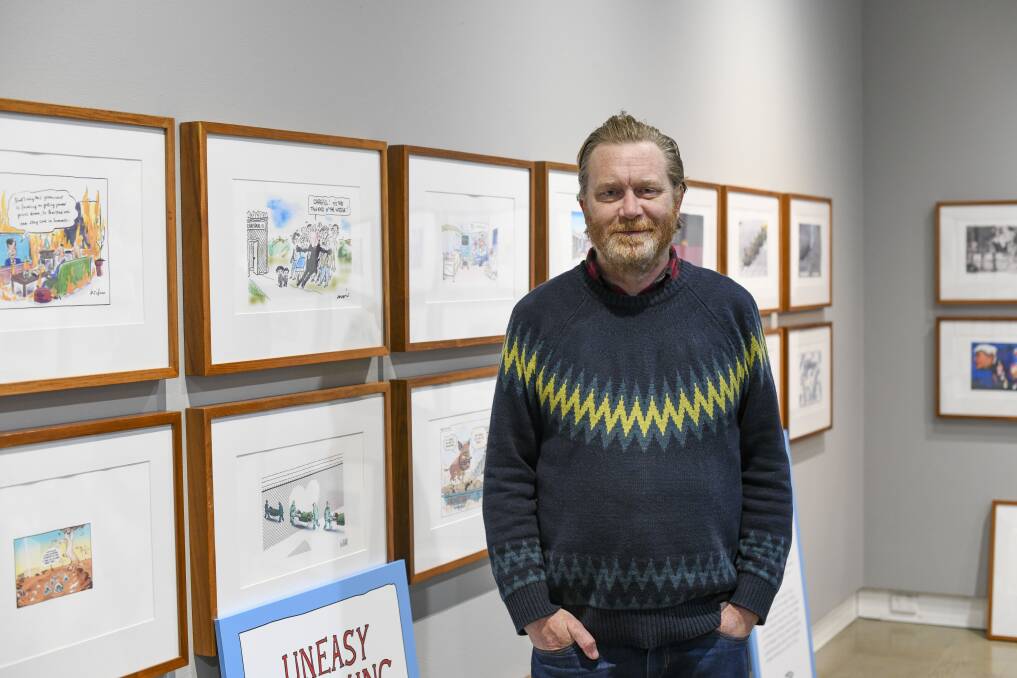NEW EXHIBITION: Curator Kent Buchanan with some of the 80 cartoons by over 30 political cartoonists on display. Photo: CONTRIBUTED
