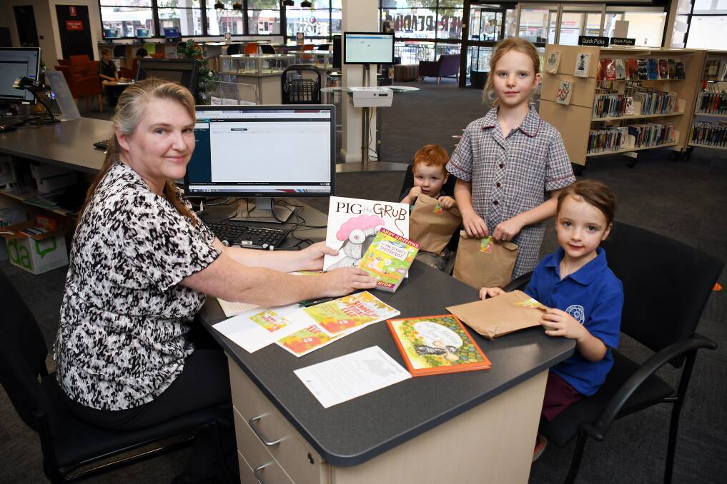 READY TO READ: Acting Dubbo libraries coordinator Anne Barwick signing Zac, Lana and Mary Estens up to the Summer Reading Club. Photo: BELINDA SOOLE