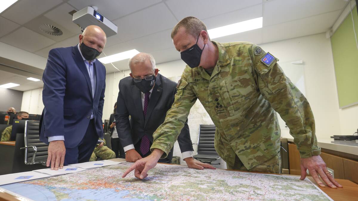 Defence Minister Peter Dutton, Prime Minister Scott Morrison and Brigadier Michael Say during the Brisbane floods. Picture: Getty Images