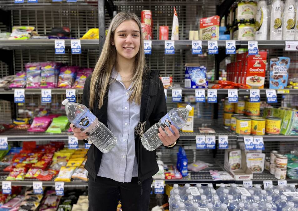 Mia Ovrahim at Ashcroft's IGA with some of the bottled water available. Photo: Benjamin Palmer