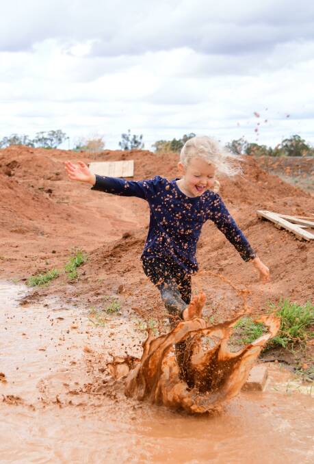 HAPPY: Chloe Lyons made the most of the rain with some fun in the mud puddles. Photo: AMY McINTYRE