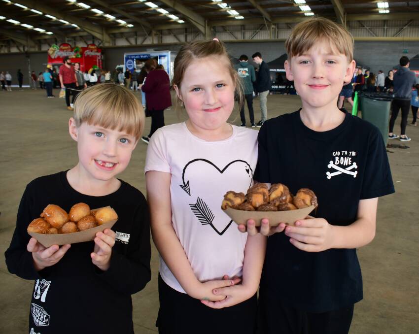 FOOD LOVERS: Darcy, Piper and Jayden Hocking enjoyed delicious filled donuts at the Foodies Markets. Photo: AMY McINTYRE. 