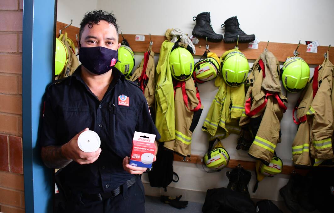 SAFTER; Firefighter Albert Wilson with a mini smoke alarm. Photo: AMY MCINTYRE