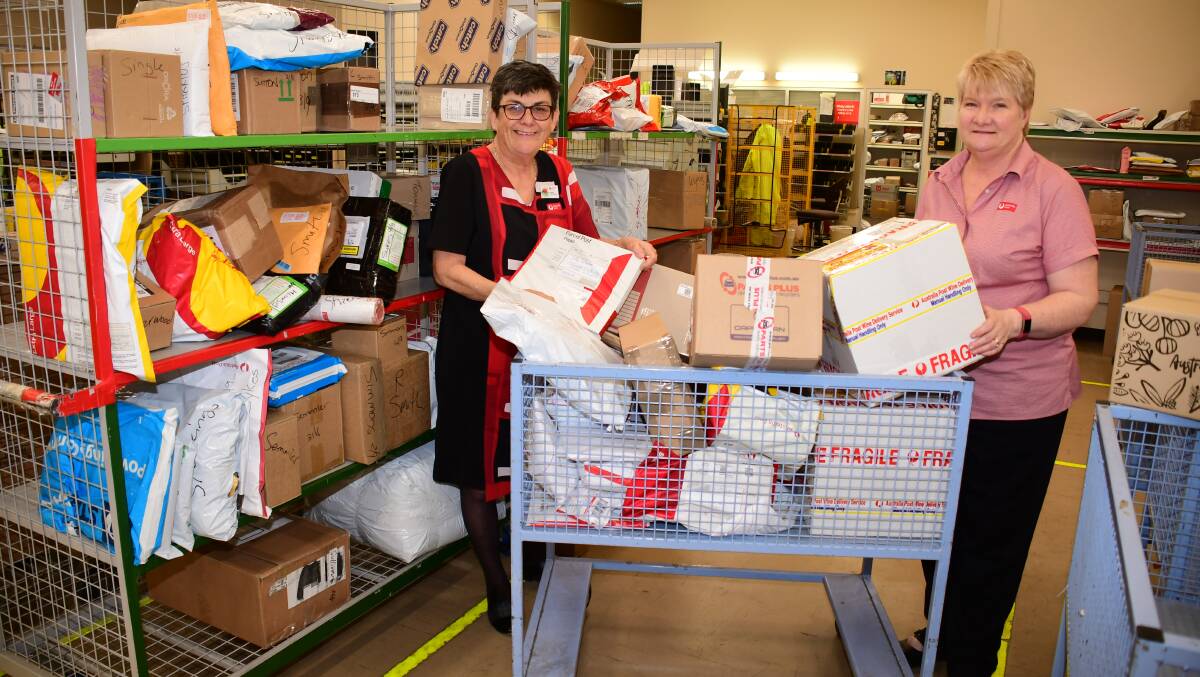 Busy: Dubbo Post Office postal manager Virginia Brown and assistant postal manager Louise Taylor with some of the parcels going out to recipients. Photo: AMY MCINTYRE