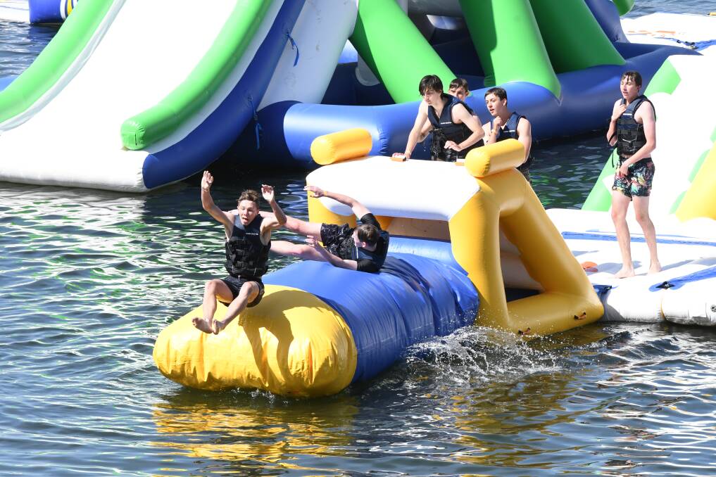 JUST GO FOR IT: These lads had a great time testing out the new Aqua Park at Ben Chifley Dam on Sunday. Photo: CHRIS SEABROOK 110418caqua1a