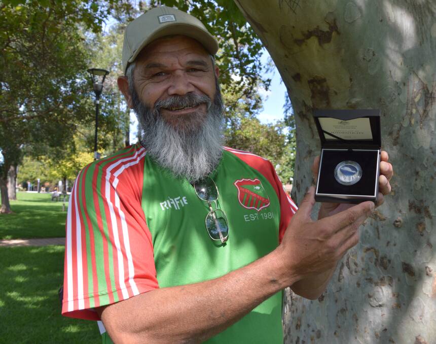 HUMBLED: Peak Hill Wiradjuri artist Scott "Sauce" Towney with his Emu in the Sky artwork on a $1 silver coin. Photo: Christine Little