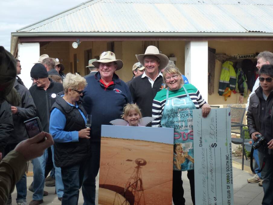 Destination Outback participants Barry (Horse) France and his wife Anne who had successfully bid for the photograph of the windmill, with hostess Jenny Lacey receiving a cheque towards a local education unit on day one at Pineview Station. Photo contributed