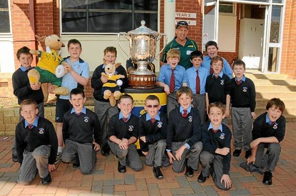 St Laurence’s students with some antique silverware yesterday as part of the Australia Rugby Unions Bledisloe Cup roadshow. Left to right: Sam Fraser, Jack Quinn, Thomas Nelson, Callum Hosking, Will Parnaby, Patrick Hennessy, Oscar Matthews, Steve Frost (Australian Rugby Union), Matt Burton, Tom Quinn, Jed McIntosh, Jordi Madden, Archie Graesser, James Dennis, Will Stellmacher, Seamus Gibb.