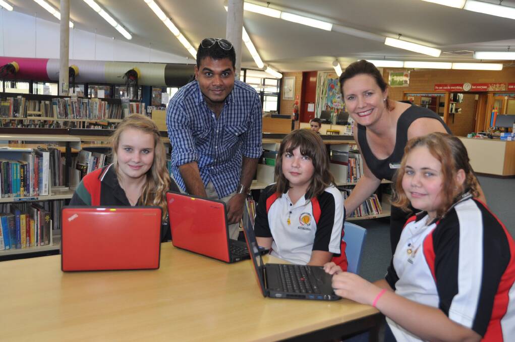 Getting ready for distribution of laptop computers to year 9 students at Delroy Campus are Chloe Dowton, computer technician Sanjay Chandran, Carmen Rogers, principal Stacey Exner and Selina Gibbs.