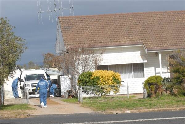 Police investigate the scene of three alleged murders in Cowra yesterday.