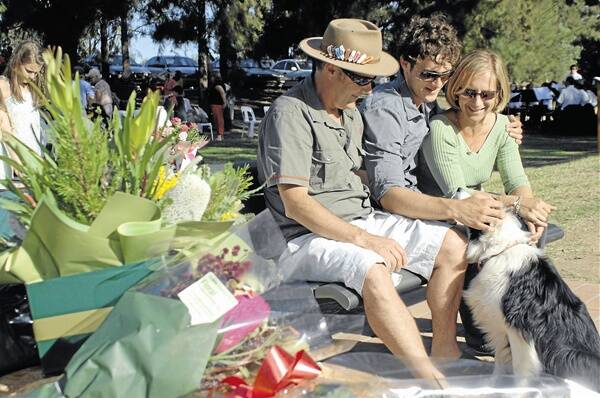 Sarah Waugh's dog Polly brings comfort to her parents Mark and Juliana and brother Jonathan after a bench dedicated to the teenager was installed at Sandy Beach. The dedication ceremony took place on March 14 2010.     Photo: Lisa Minner