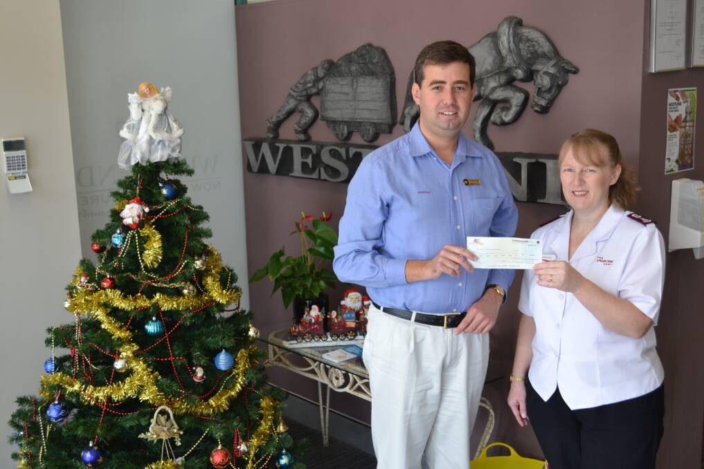 COME AND HELP US: Westfund Dubbo employee Phillip Nott hands over a $500 cheque to Dubbo's Salvation Army Major Kate Young. 	        Photo: ABANOB SAAD