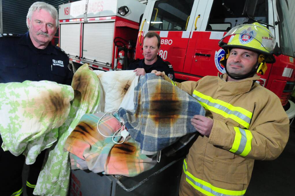 Station Officer Chris Sanders with firefighters Matt Knudsen and Graeme Combridge demonstrate an electric blanket that was seconds away from ignition. Photos: LOUISE DONGES.