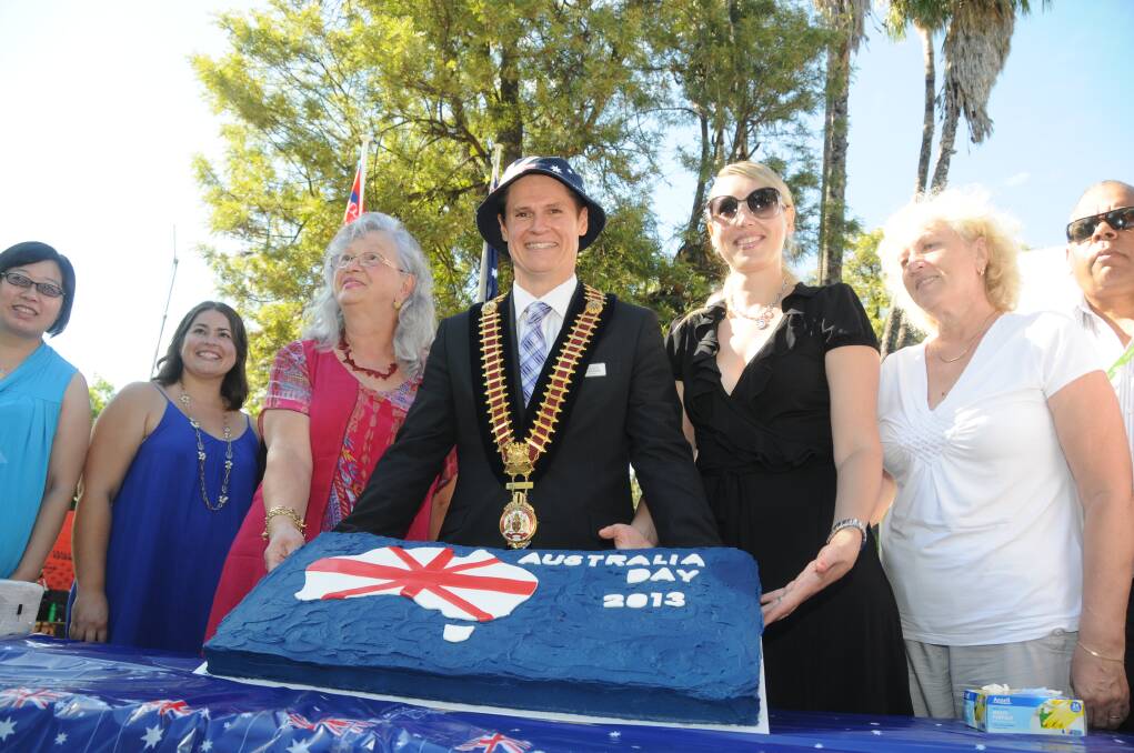 Dubbo mayor Mathew Dickerson with some of our newest citizens and an Australia Day cake. Photo: KATHRYN O'SULLIVAN