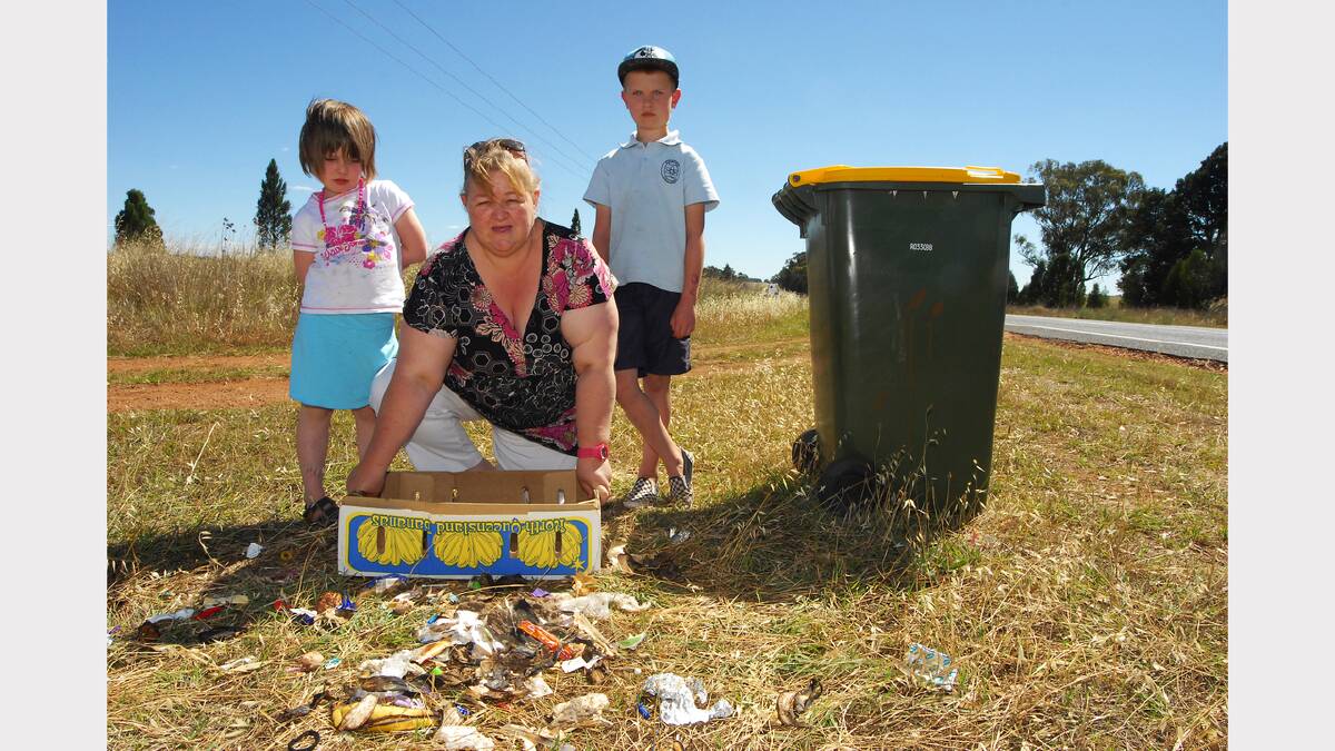 Liana Leigo, and her children Charlotte and Flynn, were upset to find their rubbish bin missing and the contents dumped in front of their home on Dunedoo Road. 	Photo: BELINDA SOOLE