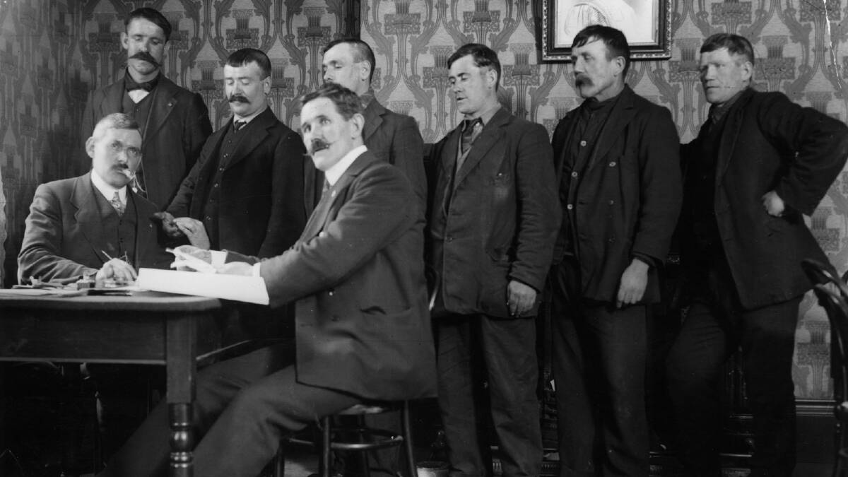 Mr J Hanson, seated right, district secretary of the National Sailors and Firemen's Union, awarding shipwreck pay to the survivors of the Titanic ship disaster. Photo by Topical Press Agency/Getty Images