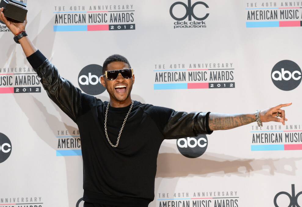 Singer Usher poses with the Favorite Soul/R&B Male Artist award in the press room at the 40th American Music Awards held at Nokia Theatre L.A. Live in Los Angeles, California. Photo by Jason Merritt/Getty Images