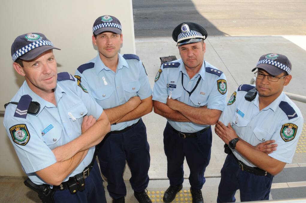 Dubbo police wearing white ribbons in support of an end to domestic and family violence against women yesterday. Pictured are Senior Constable Jason Pollack, Constable Michael Dawn, Inspector Brad Edwards, Constable Tofazzal Ali. 	Photo: LISA MINNER