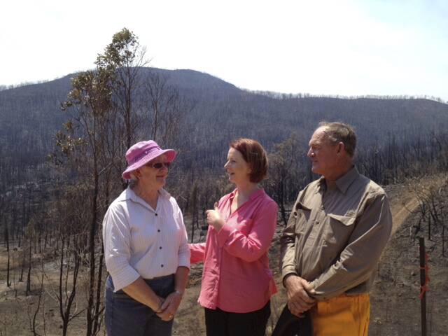 Prime Minister Julia Gillard with Bob and Jeanette Fenwick who lost their property in the Wambelong fires. 		    Photo: Jacky Ghossein, SMH